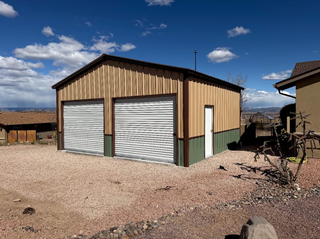 24 x 22 tan metal garage with green wainscot and two white roll-up doors